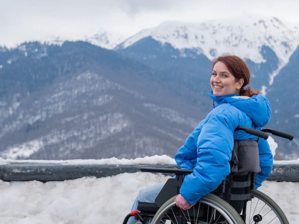 Frau im Rollstuhl in den Bergen