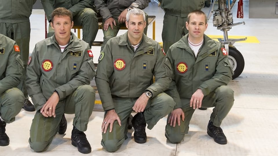Man sieht drei Militärpiloten kniend. In der Mitte der grauhaarige Gunnar Jansen.