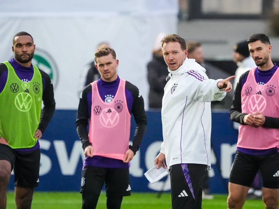 Trainer mit Fussballspielern auf dem Trainingsplatz.