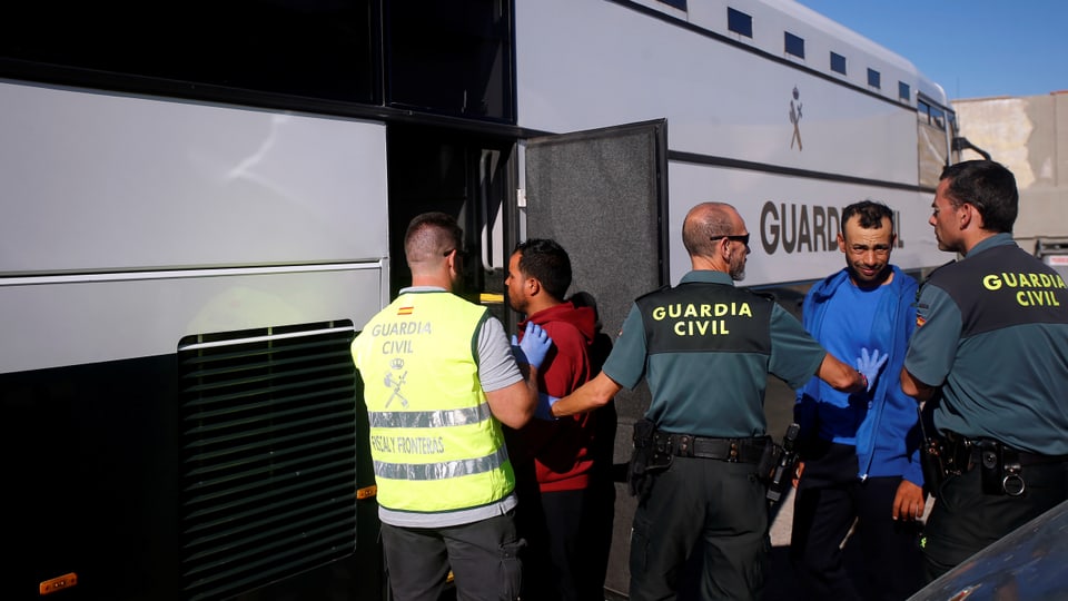 Migranten steigen in einen Bus