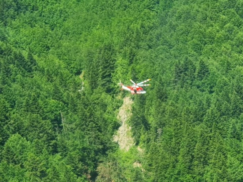 Helikopter kreist über gebirgiger Unfallstelle