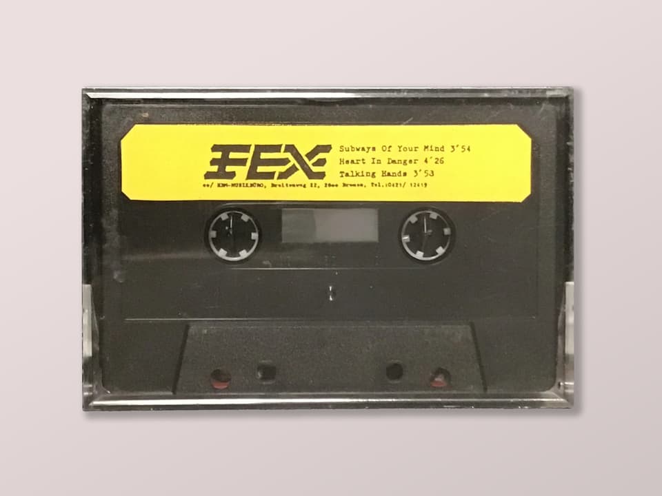 Schwarze Audiokassette in Hülle mit gelbem Etikett.