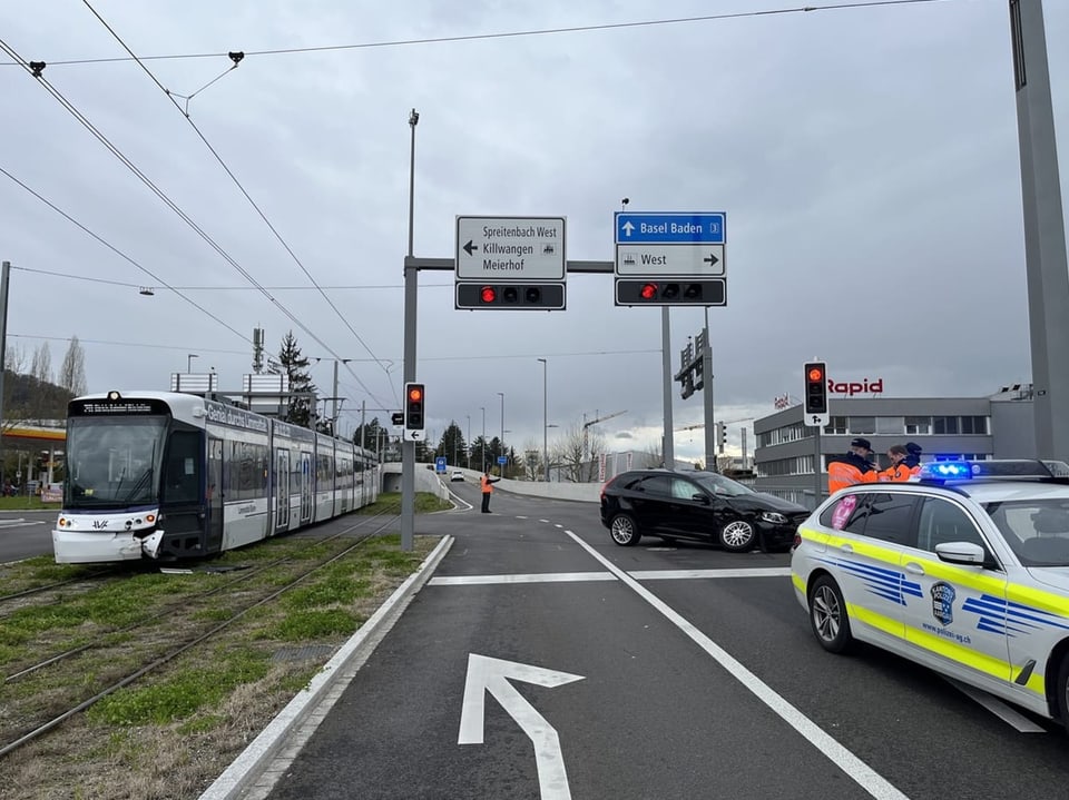 Eine Hauptstrasse, links ein beschädigtes Tram und rechts ein Polizeiauto. 