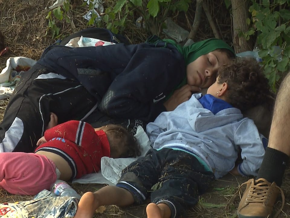 Flüchtlings-Familie schläft, erschöpft von ihrem Marsch.