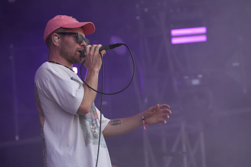 Sänger mit Mikrofon auf der Bühne am Open Air Lumnezia 2024.