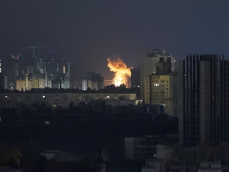 Nachtansicht einer Stadt mit Explosion zwischen Gebäuden.