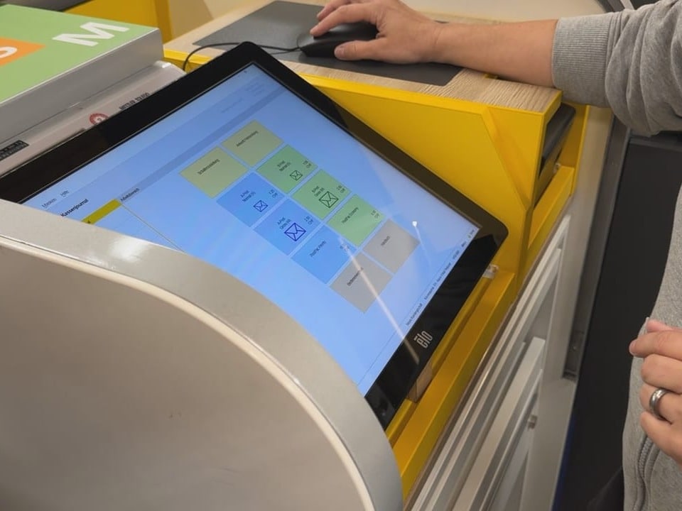 Person bedient Touchscreen an gelber Maschine.