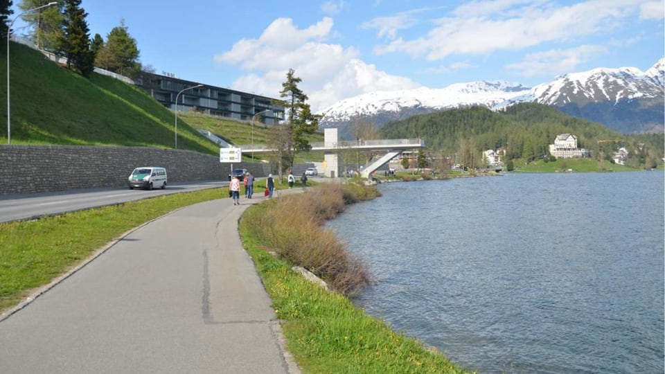 Seepromenade St. Moritz mit Kantonsstrasse und asphaltierter Strasse für Langasamverkehr und Alpen im Hintergrund.