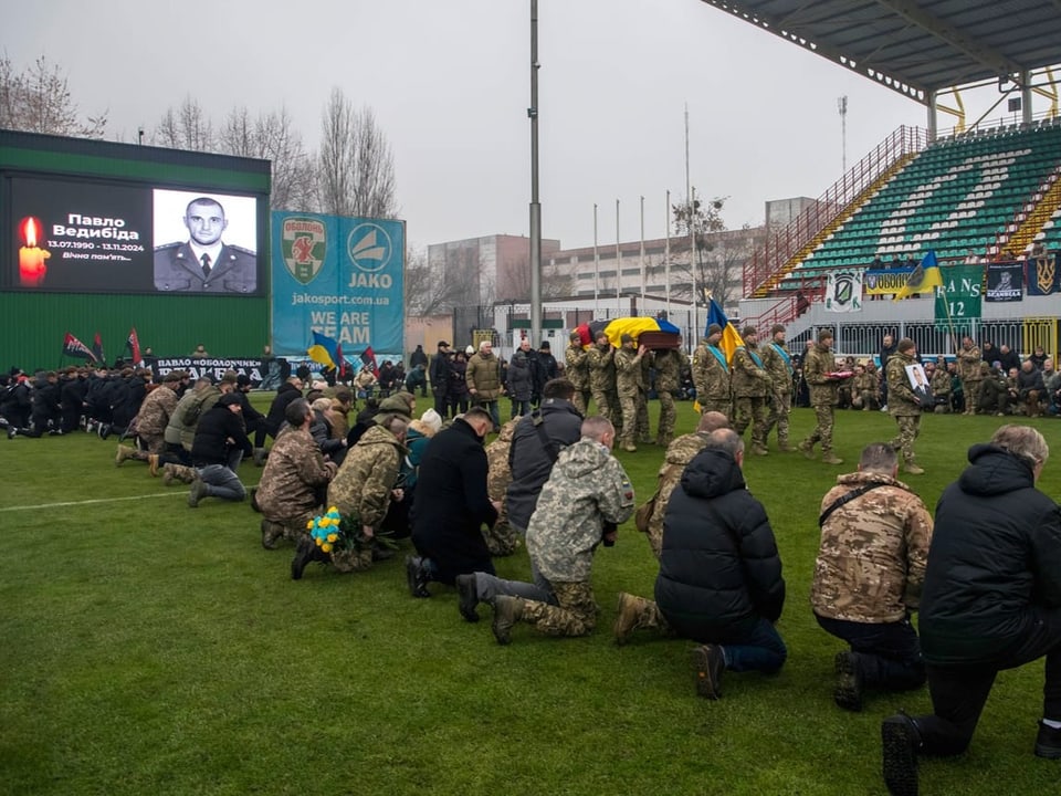 Trauernde Soldaten knien auf dem Spielfeld