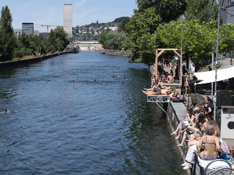 Menschen entspannen sich am Flussufer in der Stadt.