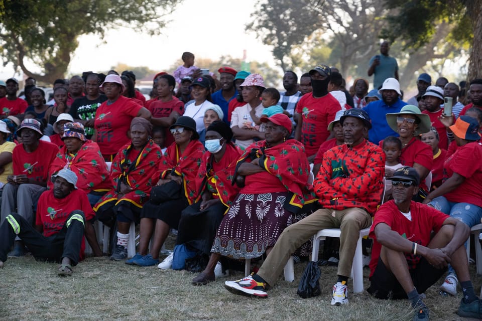 Manner und Frauen sitzen einem Halbkreis bei einer Veranstaltung der Partei EFF. Alle tragen rote Shirts
