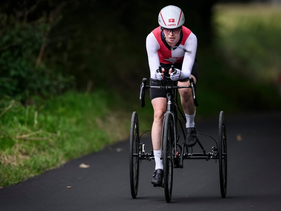 Sportler auf einem Renntrike auf der Strasse.