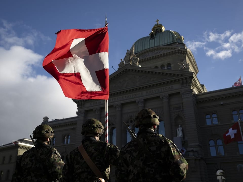 Angehörige der Armee mit Schweizer Fahne vor BUndeshaus bei Macrons Staatsbesuch