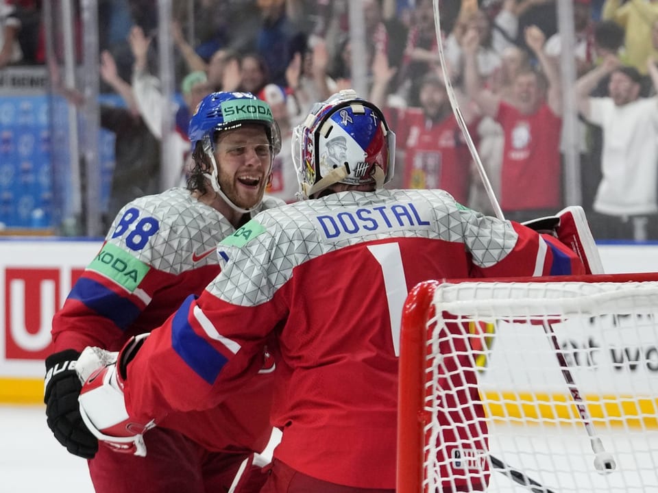 Eishockeyspieler in roter Uniform feiern ein Tor.