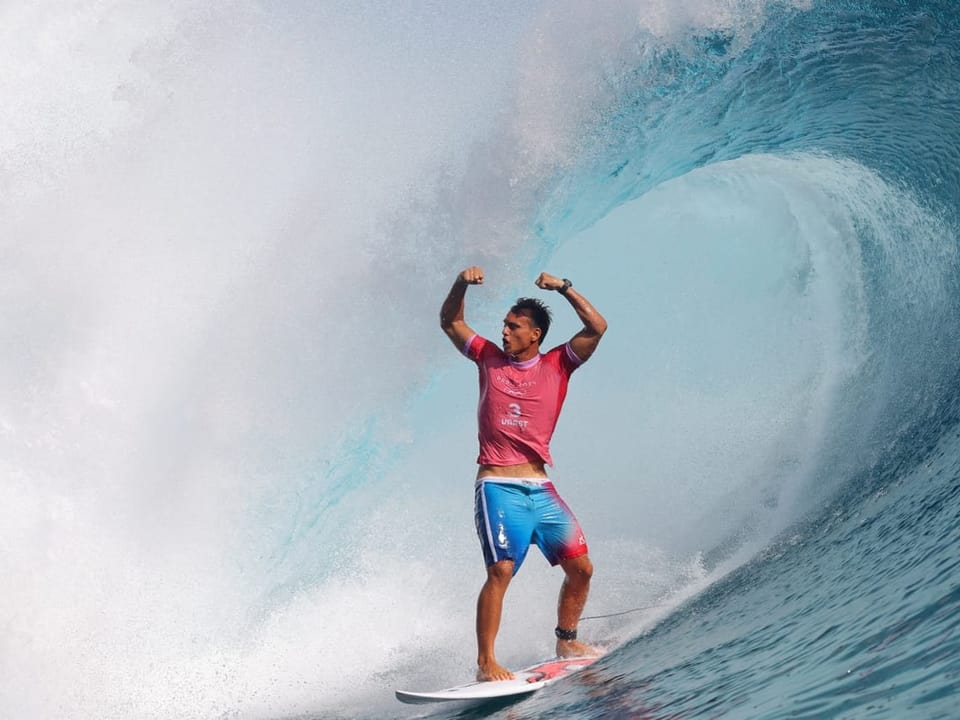 Surfer posiert auf einer grossen Welle.