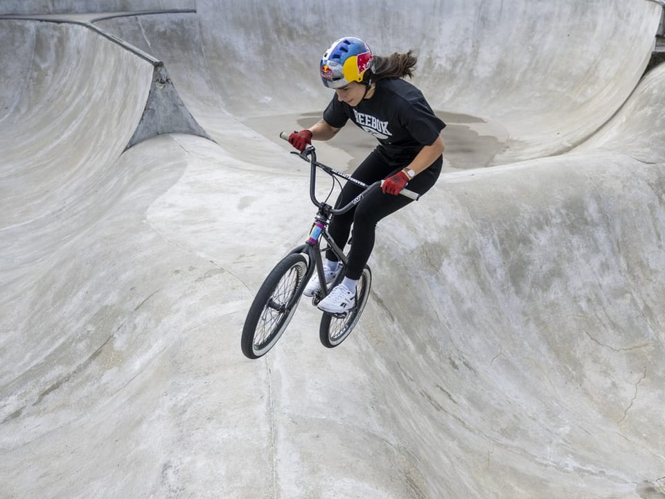 Fahrradfahrer macht Kunststücke in einer Skatepark-Halfpipe.
