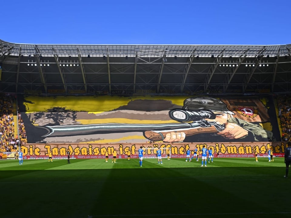 Fussballstadion mit grossem Banner eines Scharfschützen.