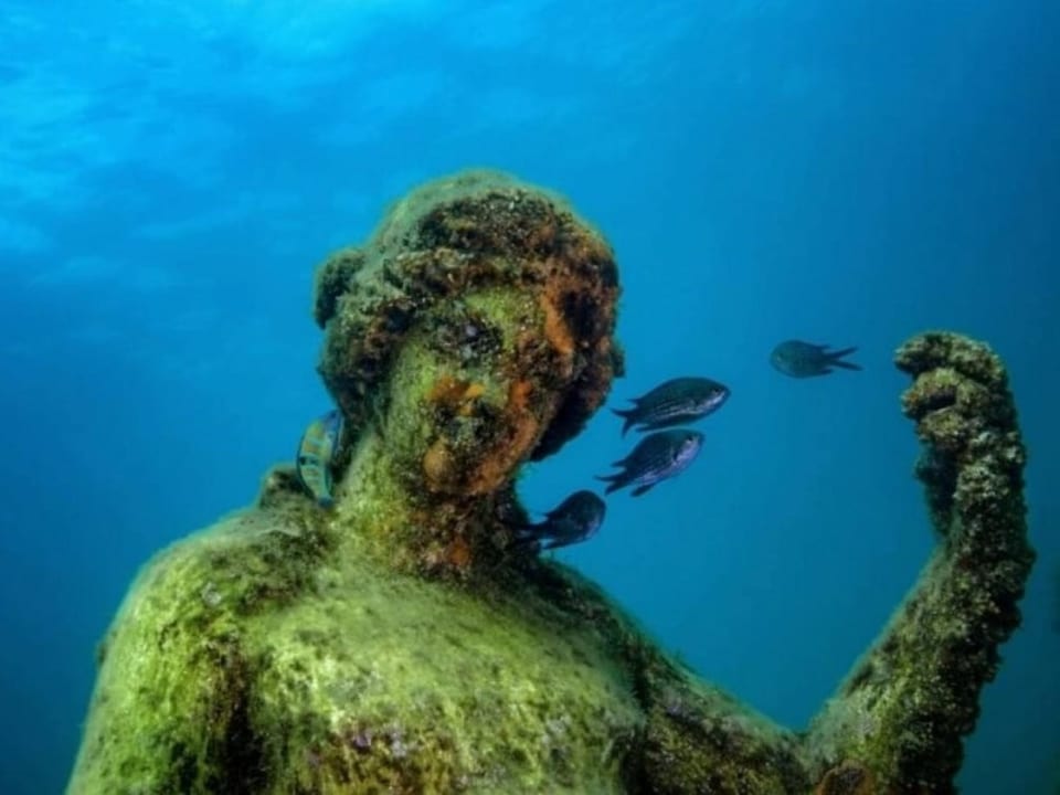 Unterwasserstatue mit Fischen.