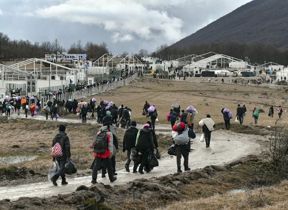 Migranten und Flüchtlinge kehren in das abgebrannte Lager zurück
