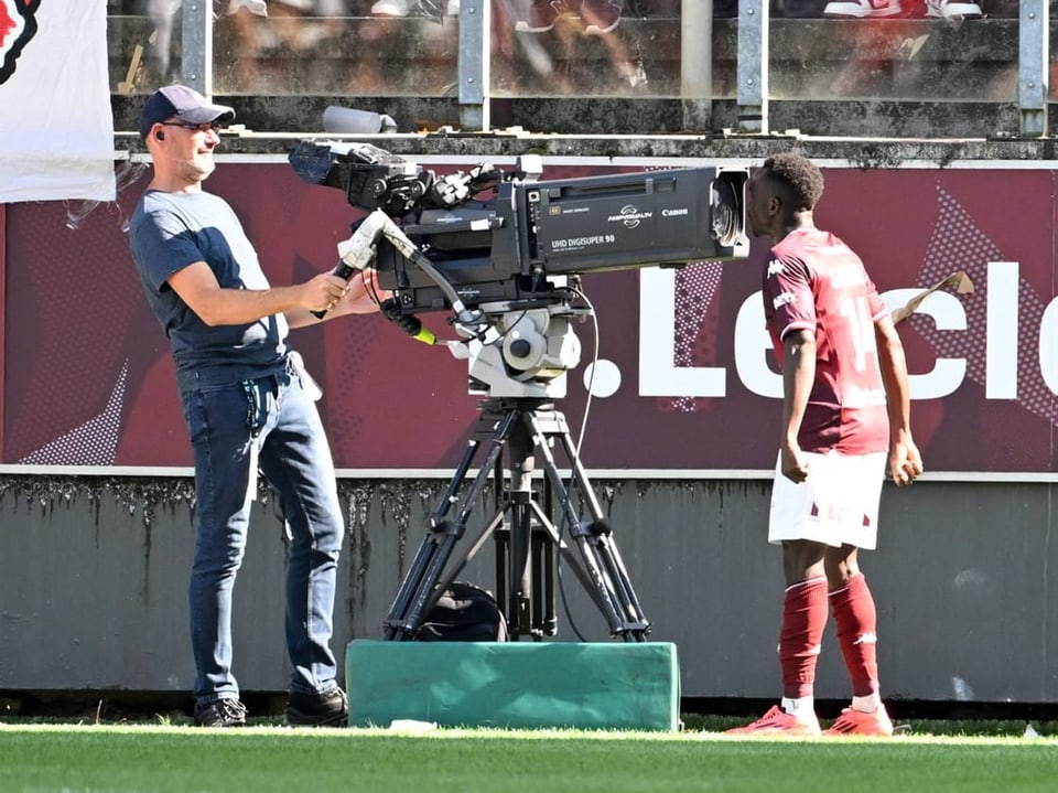 Kameramann filmt Fussballspieler am Spielfeldrand.