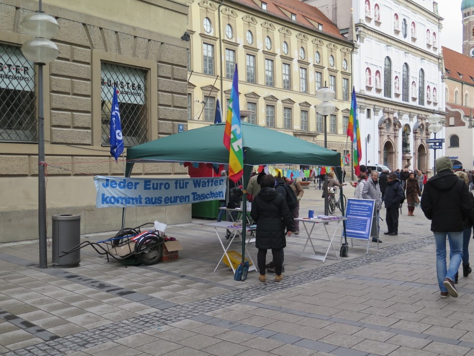 Zu sehen ist ein Stand mit einem Transparent «Jeder Euro für Waffen kommt aus euren Taschen»