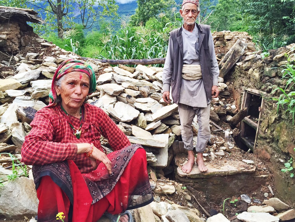 Nepalische Frau (links) und ihr Mann in den Trümmern ihres Hauses