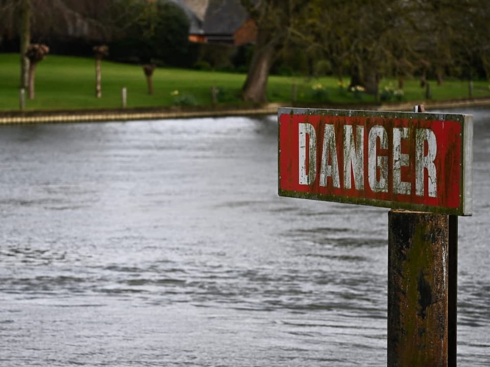 Warnschild 'Danger' am Flussufer.