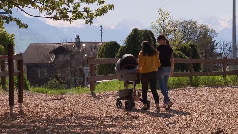 Sophie und Nathalie schieben den Kinderwagen durch einen Park.