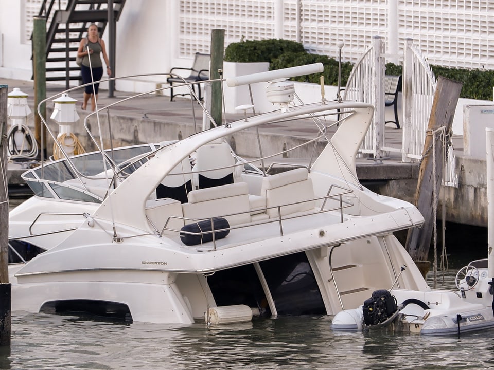 Eine Motoryacht liegt überflutet an einer Hafen-Mole in Miami.