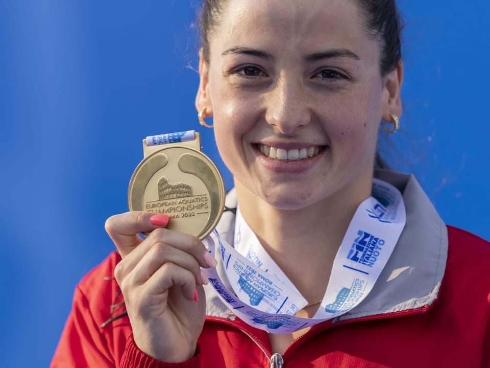 Frau zeigt Medaille bei den Europäischen Schwimmmeisterschaften 2022.