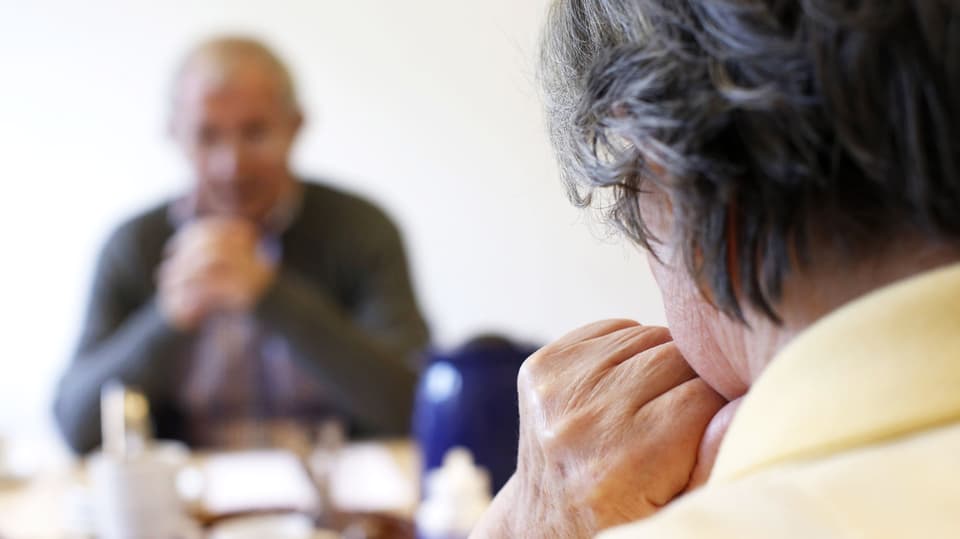 Eine Frau schaut einen Mann an. Er ist verschwommen.