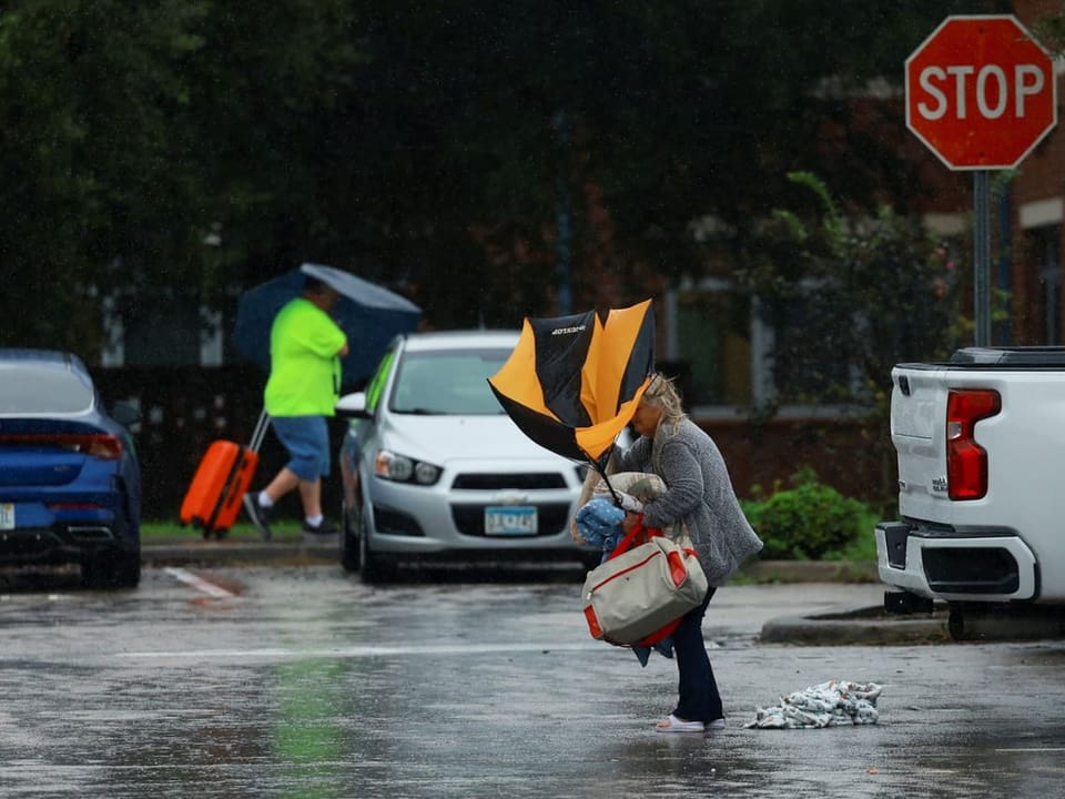 Eine Frau trägt einen Regenschirm. 