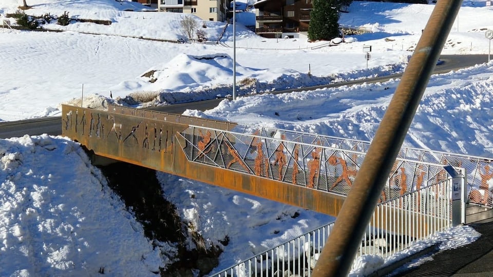 Brücke mit Kunstfiguren über einen kleinen Bachlauf.