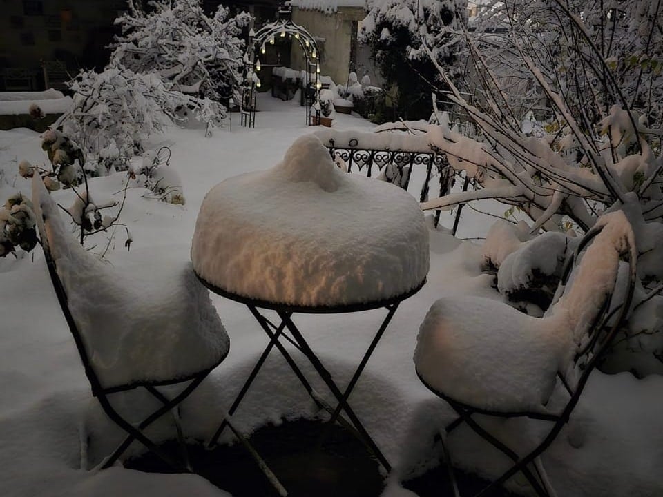 Verschneite Gartenmöbel im Winter.