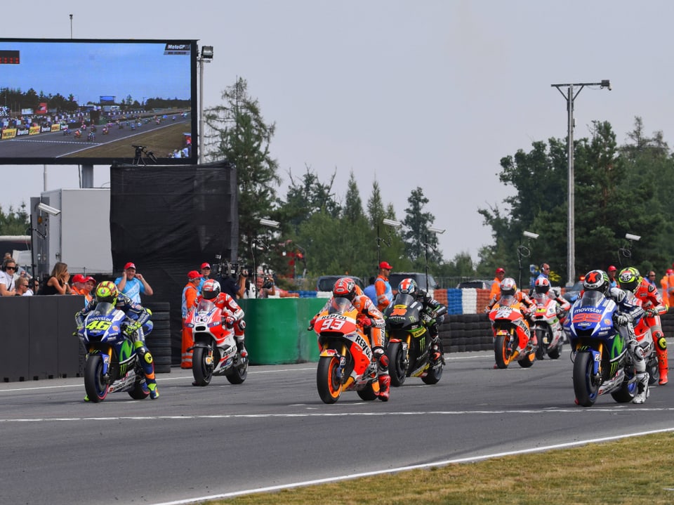 Motorradrennfahrer auf einer Rennstrecke beim Start.