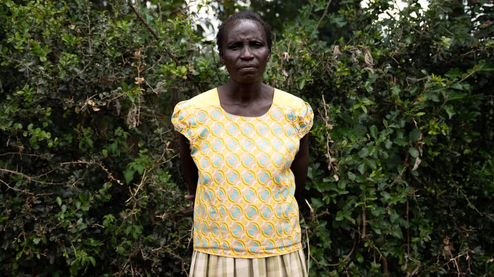 Nachbarin Agnes Barbara vor grünem Busch in gelb gemustertem Shirt und grünen Jupe. 