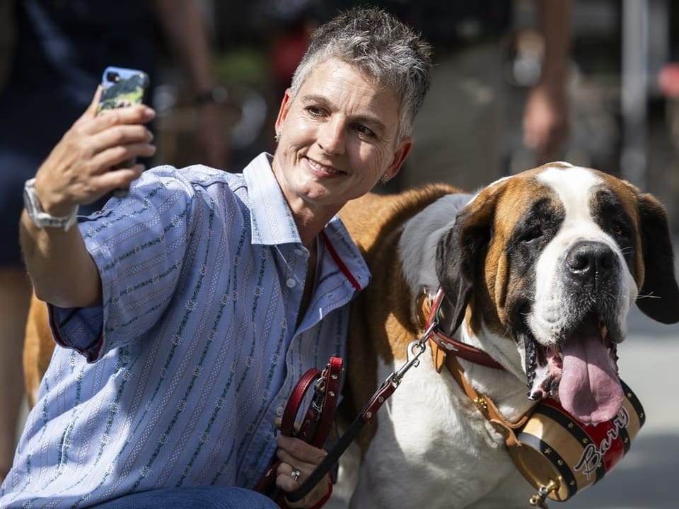 Eine Frau macht ein Selfie mit einem Berner Sennenhund