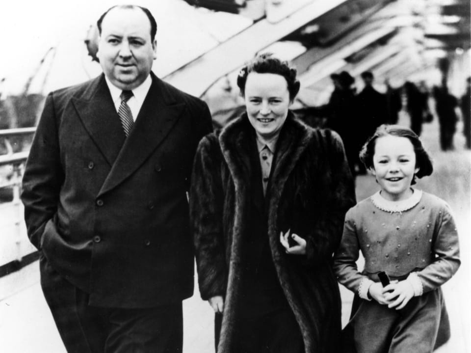 Eine Familie spaziert auf einem Schiff, schwarz-weiss Foto.