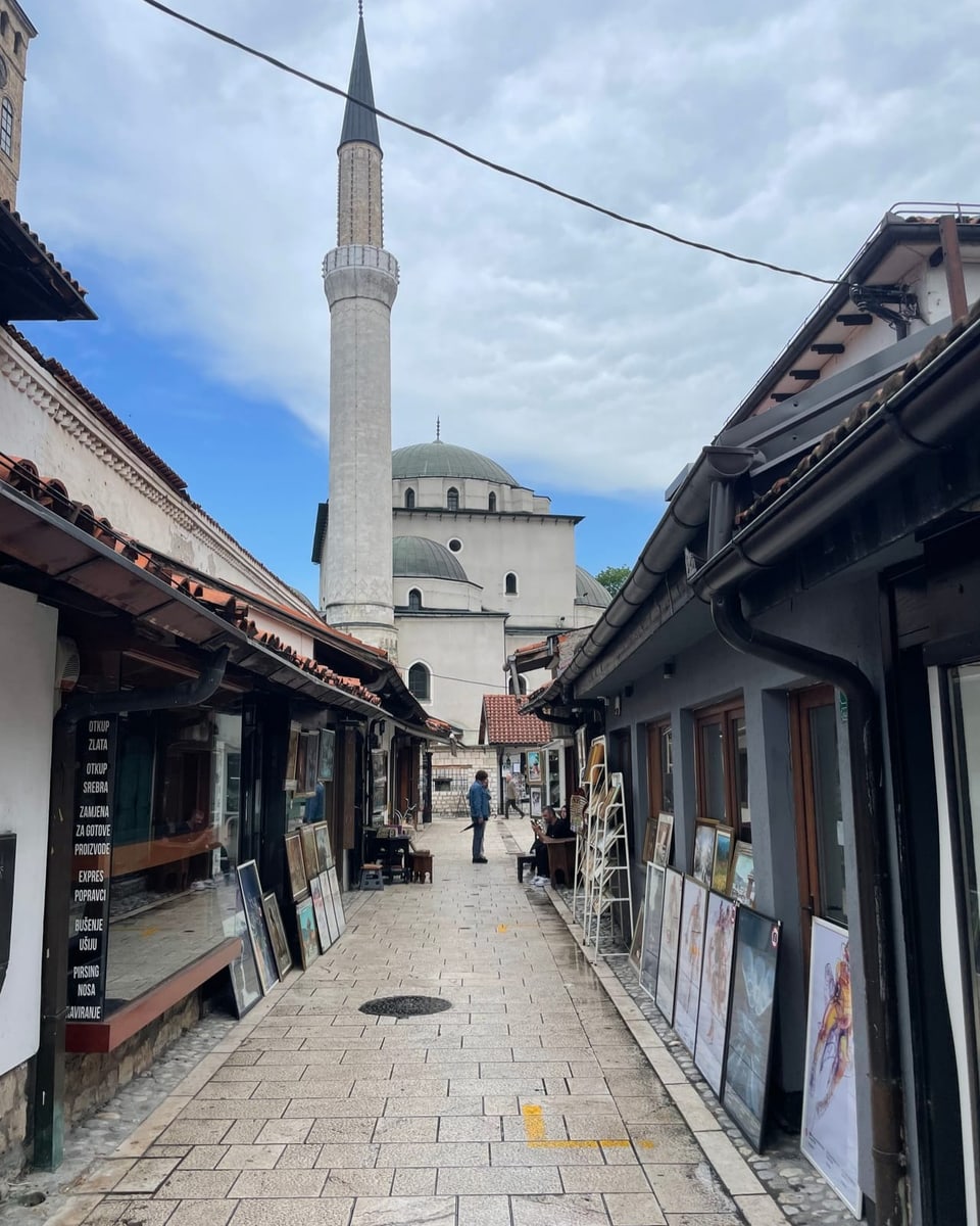 Gasse mit Kunstgalerien und Blick auf eine Moschee.