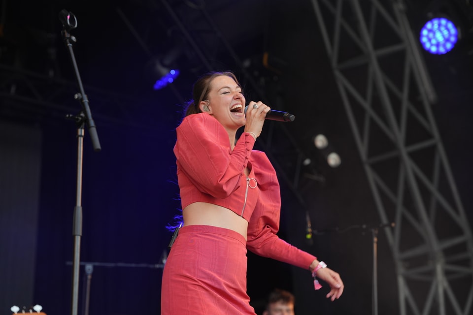 Sängerin auf der Bühne singt ins Mikrofon am Open Air Lumnezia 2024.