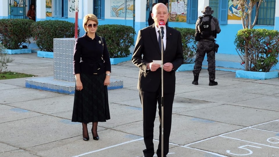 Präsident Kais Saied mit seiner Frau im Hintergrund.