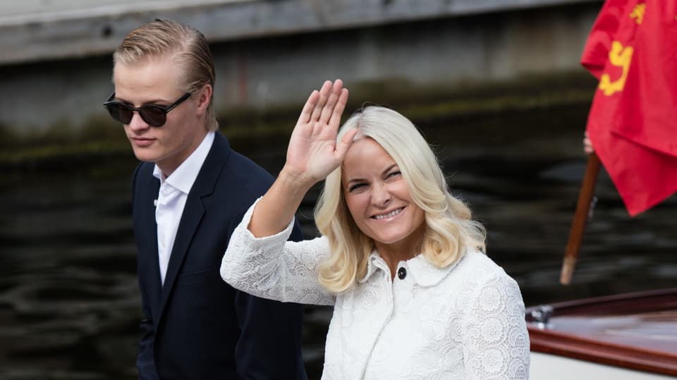 Marius Borg Høiby mit Sonnenbrille und Anzug, Mette-Marit im weissen Mantel.