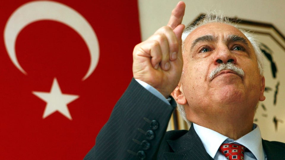 Dogu Perincek vor einer türkischen Nationalflagge