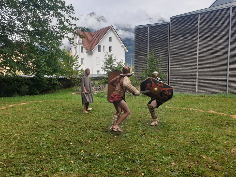 Dus umens sin in prà en mondura da gladiatur vid cumbatter.