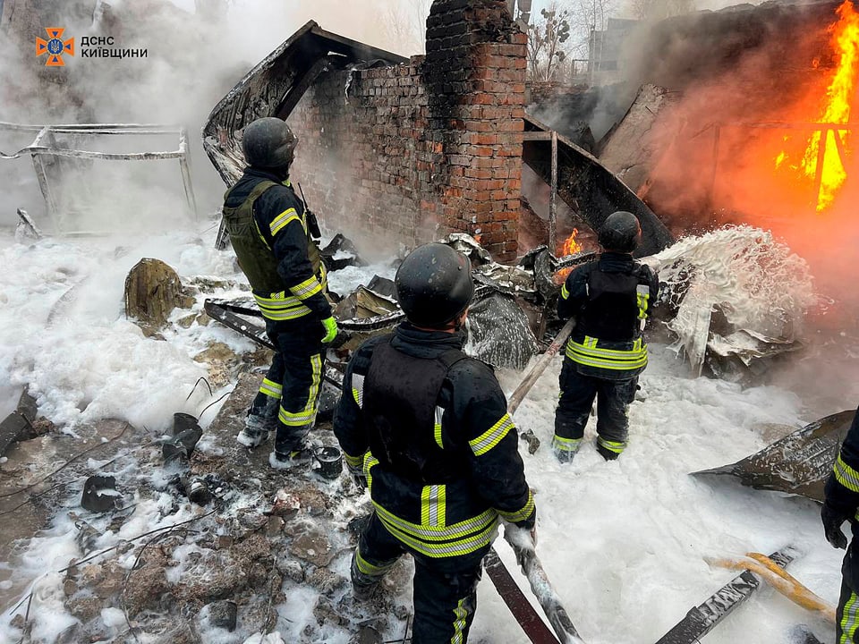 Sicherheitskräfte in Kiew löschen einen Brand.