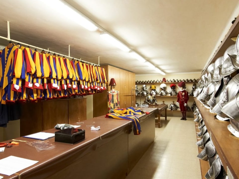 Viele Uniformen in hängen bereit in einem Raum, der wie ein Keller wirkt.