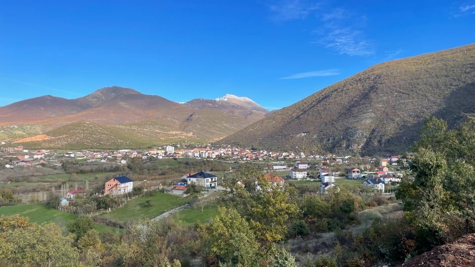 Ein Blick auf Kukes. Versträute Häuser vor bergiger Landschaft