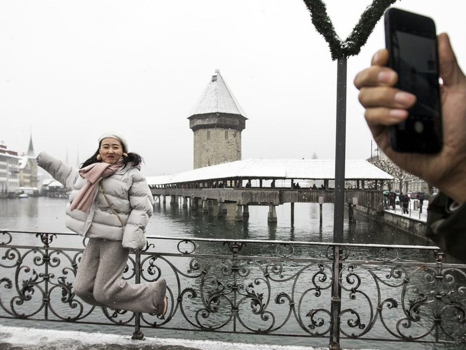 Touristin posiert für ein Selfie vor der Kapellbrücke.