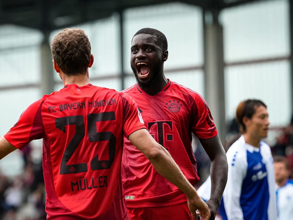 FC Bayern München Spieler feiern auf dem Fussballplatz.