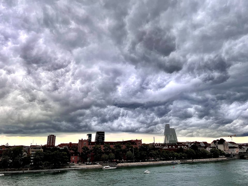 Dramatische Wolken über einer Stadt am Fluss.